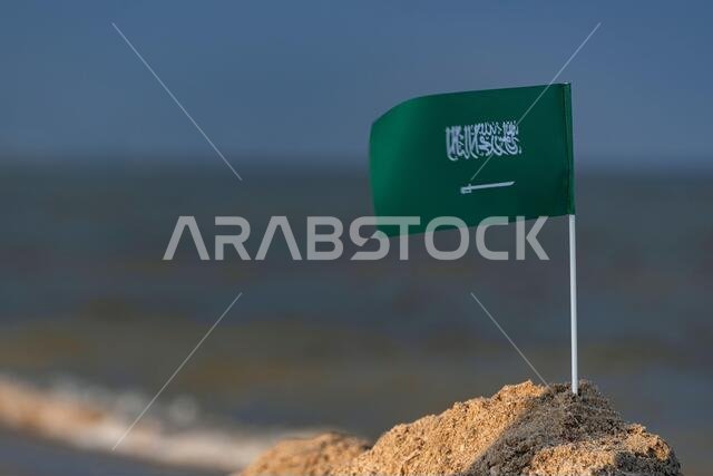 Flag of Saudi Arabia on sea background. Vacation in Saudi Arabia . Green flag with sword