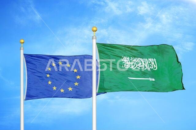 الاتحاد الأوروبي والمملكة العربية السعودية، علمان على سارية العلم، وسماء زرقاء ملبدة بالغيوم