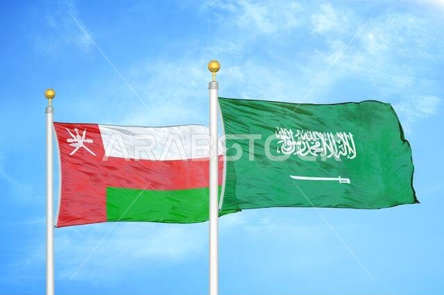 Oman and Saudi Arabia two flags on flagpoles and blue sky