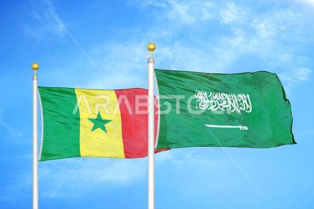 Senegal and Saudi Arabia two flags on flagpoles and blue cloudy sky