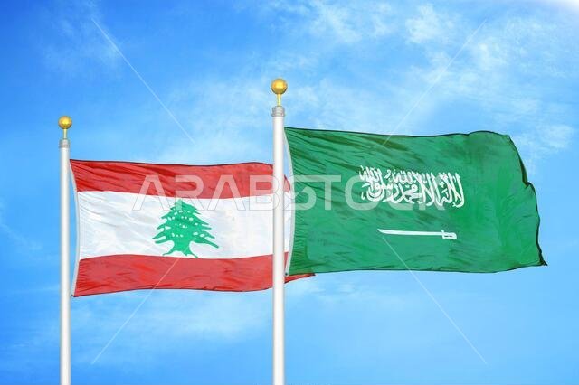 Lebanon and Saudi Arabia two flags on flagpoles and blue cloudy sky