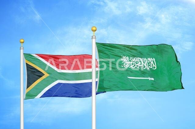 جنوب أفريقيا والمملكة العربية السعودية، علمان على سارية العلم، وسماء زرقاء جنوب أفريقيا والمملكة العربية السعودية، علمان على سارية العلم، وسماء زرقاء