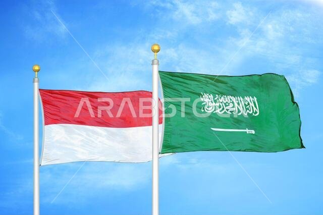 Indonesia and Saudi Arabia two flags on flagpoles and blue cloudy sky