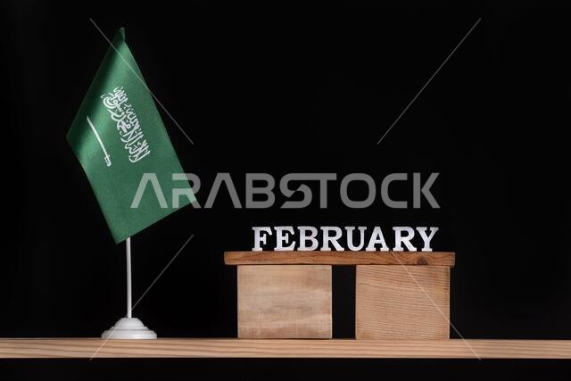 Wooden calendar of February with Saudi Arabia flag on black background. Dates of Saudi Arabia in February.