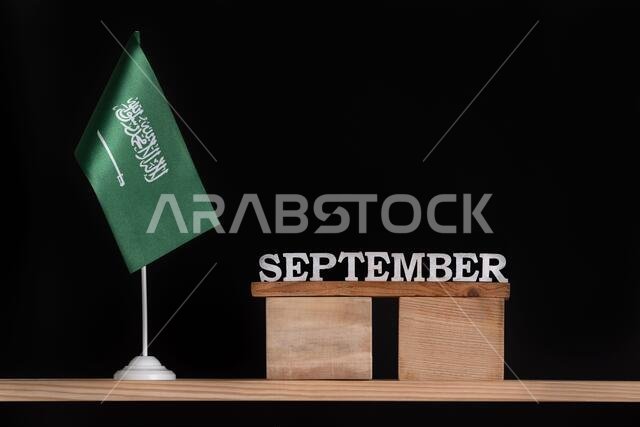 Wooden calendar of September with Saudi Arabia flag on black background. Dates of Saudi Arabia in September.