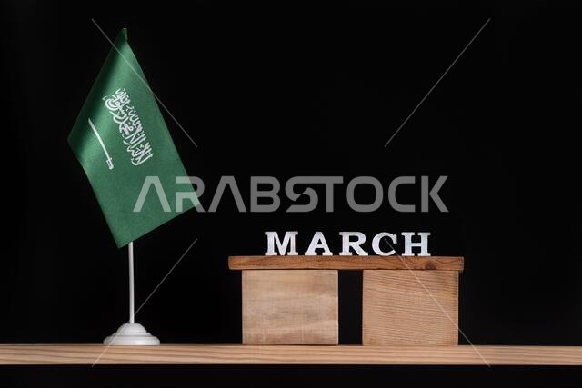 Wooden calendar of March with Saudi Arabia flag on black background. Dates of Saudi Arabia in March.