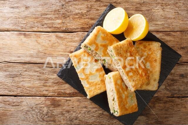 خبز مطبق لذيذ، وهو خبز مسطح مطوي ومقلي، محشو بلحم مفروم متبل قليلاً وبيض، يظهر عن قرب في الطبق الموضوع على الطاولة.