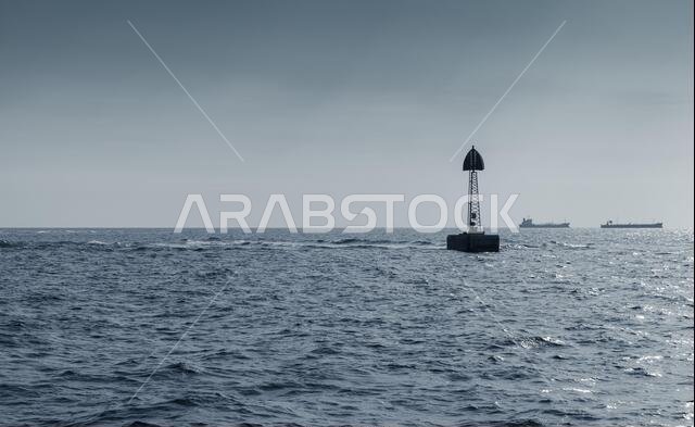 يقع برج بيكون على حدود الممر، وهو برج مؤطر يعلوه مثلث، ويقف في مياه الخليج العربي، المملكة العربية السعودية. صورة أحادية اللون بدرجات اللون الأزرق