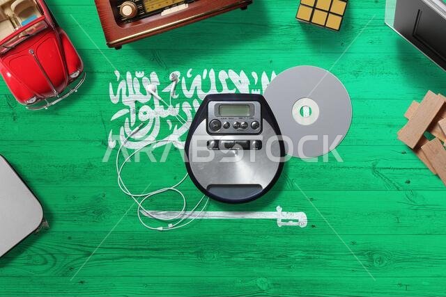 Saudi Arabia flag on wooden desk with retro digital media concept. National entertainment theme.