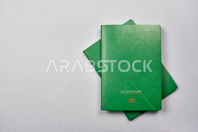 Two green passports of a muslim country on the gray background. From above
