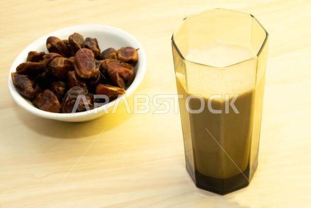 Hushaf - date milk, traditional Ramadan dish, cooking, ingredients, glass with date milk - khushaf and dish with dates are on the table