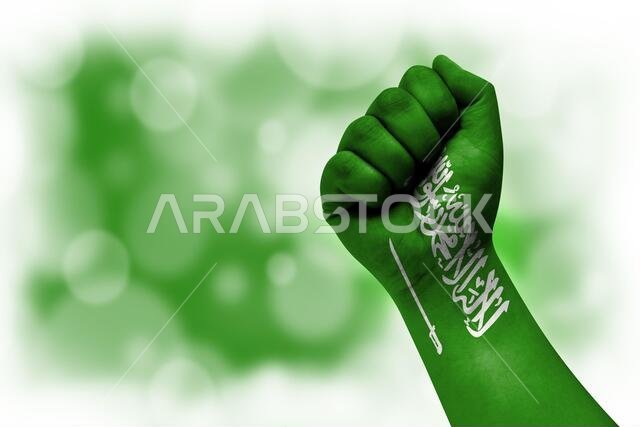 علم المملكة العربية السعودية مرسوم على قبضة رجل، رمزاً للقوة والسلطة ومفهوم الصراع. على خلفية ضبابية.