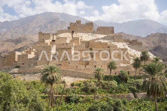 منظر طبيعي خلاب لقرية الرخام القديمة النائية في منطقة الباحة، تتناقض مع سماء ملبدة بالغيوم في يوم صيفي غائم في المملكة العربية السعودية.