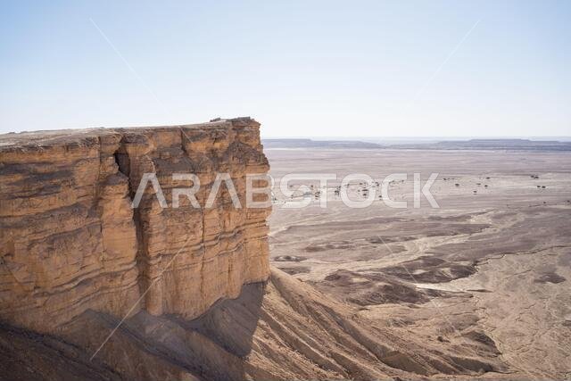 من الأعلى، يمكنك الاستمتاع بمناظر خلابة لسلسلة جبال مهيبة في موقع صحراوي على حافة العالم في المملكة العربية السعودية.