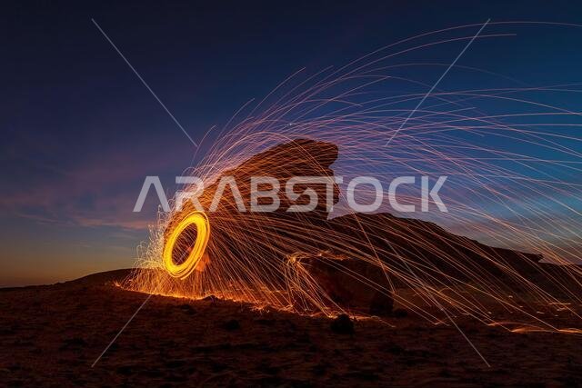 A steel wool on fire at night (night photography using a slow shutter speed) - selective focused on the subject.