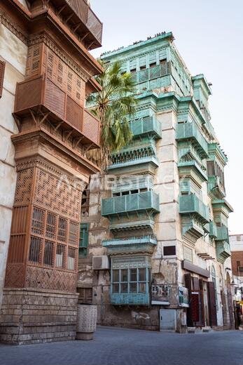 Low angle of aged stone buildings with shabby walls and balconies on street of Jeddah city in Saudi Arabia