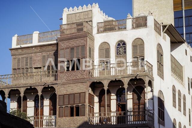 زاوية منخفضة لمبانٍ حجرية قديمة ذات جدران وشرفات متداعية في أحد شوارع مدينة جدة بالمملكة العربية السعودية