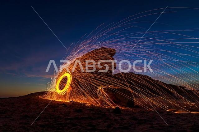 صوف فولاذي مشتعل ليلاً (التصوير الليلي باستخدام سرعة غالق بطيئة) - تركيز انتقائي على الموضوع.