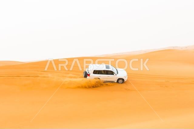 4x4 jeep car riding through the Arabian golden desert sand dunes during a safari tour. Tourism and travel destination.