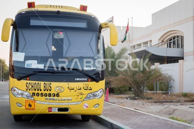 Yellow school bus in Abu Dhabi, United Arab Emirates, Dubai, Emirates, Gulf, Middle east. Awareness signs and symbol was written in arabic language at