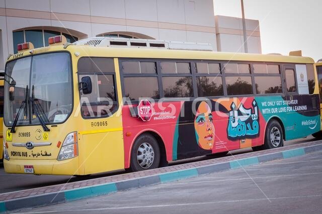 حافلة مدرسية صفراء في أبو ظبي، الإمارات العربية المتحدة، دبي، الإمارات، الخليج، الشرق الأوسط. كُتبت لافتات ورموز توعوية باللغة العربية في