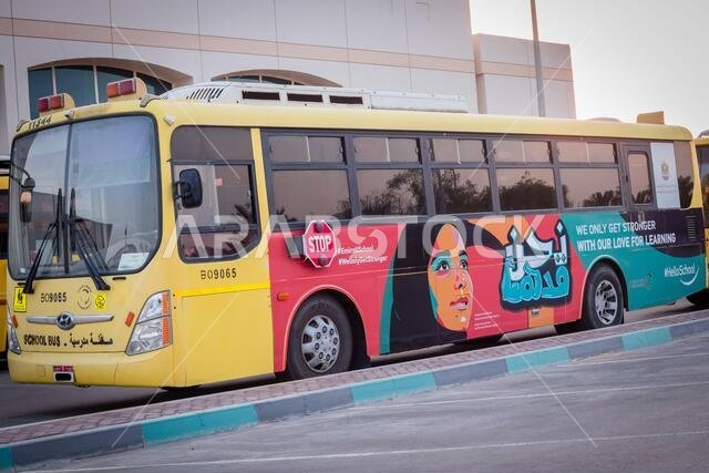 حافلة مدرسية صفراء في أبو ظبي، الإمارات العربية المتحدة، دبي، الإمارات، الخليج، الشرق الأوسط. كُتبت لافتات ورموز توعوية باللغة العربية في
