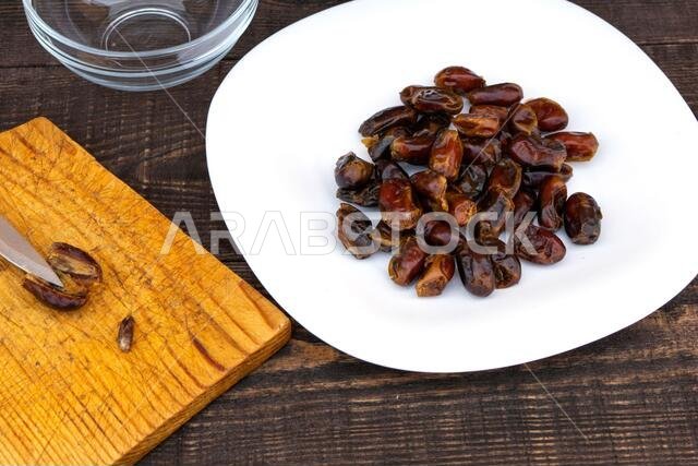 Hushaf - date milk, a traditional dish of Ramadan, cooking, ingredients, cut pitted dates, a knife and a date stone lie on a cutting board, there is t