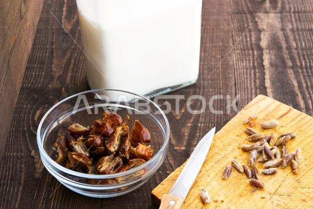 حمص - حليب التمر، طبق رمضاني تقليدي، طريقة التحضير، المكونات، تمر منزوع النوى في طبق، سكين وبذور على لوح تقطيع، والحليب في زجاجة