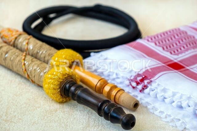 Traditional Arab Male Clothes - kaffiyah, igal, and hookah craft wooden accessories close-up. Traditional Arab Male Clothes - kaffiyah, igal, and hookah craft wooden accessories close-up.
