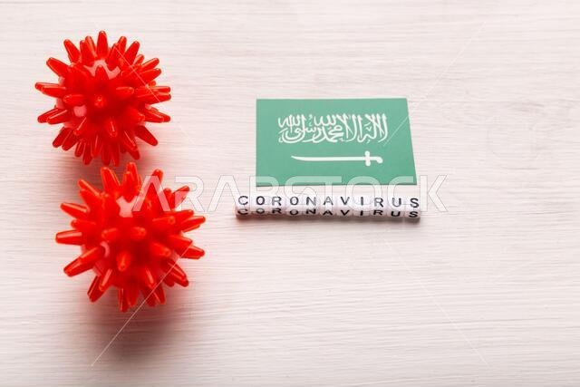 مفهوم هجوم فيروس كورونا. السعودية تكافح كوفيد-19. تصور لكيفية هجوم فيروس كورونا على السعودية، على خلفية بيضاء، من الأعلى.