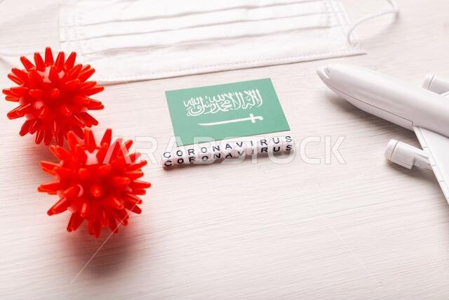 نموذج طائرة وقناع وجه وعلم المملكة العربية السعودية. جائحة فيروس كورونا. حظر الطيران وإغلاق الحدود أمام السياح والمسافرين المصابين بفيروس كورونا (كوفيد-19). نموذج طائرة وقناع وجه وعلم المملكة العربية السعودية. جائحة فيروس كورونا. حظر الطيران وإغلاق الحدود أمام السياح والمسافرين المصابين بفيروس كورونا (كوفيد-19).