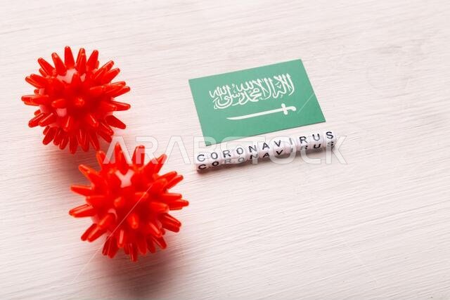 مفهوم هجوم فيروس كورونا. السعودية تكافح كوفيد-19. تصور لكيفية هجوم فيروس كورونا على السعودية، على خلفية بيضاء، من الأعلى.