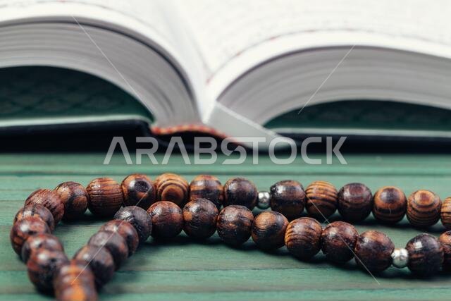 The Open holy Quran with tasbih rosary beads close up