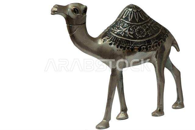 Metal model of a camel with intricate design on its back against a white background