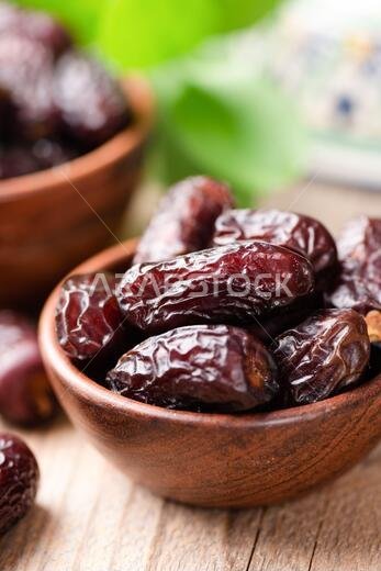 تمر مجدول مجفف في وعاء على خلفية طاولة خشبية. طعام شرقي عربي
