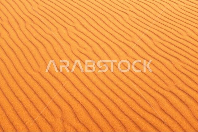 Bright orange desert sand pattern ripples for a warm summer background.