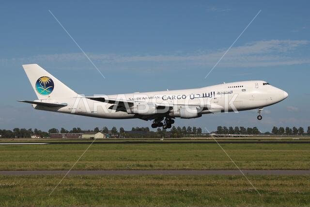 طائرة الشحن السعودية من طراز بوينغ 747-200F المسجلة برقم EK74799 في المرحلة النهائية القصيرة للهبوط على المدرج 18R (بولدربان) في مطار سخيبول بأمستردام. طائرة الشحن السعودية من طراز بوينغ 747-200F المسجلة برقم EK74799 في المرحلة النهائية القصيرة للهبوط على المدرج 18R (بولدربان) في مطار سخيبول بأمستردام.