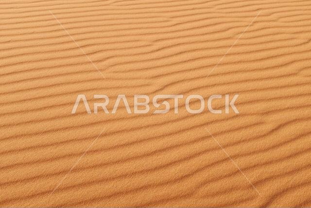 تموجات رملية برتقالية زاهية على شكل رمال صحراوية لخلفية صيفية دافئة.