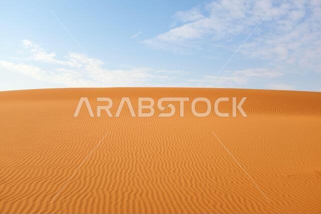 تموجات رمال الصحراء البرتقالية الزاهية وسماء زرقاء صافية لخلفية صيفية دافئة.