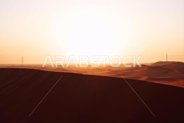 شروق شمس ساطع على الكثبان الرملية الحمراء لصحراء الدهناء في الرياض، المملكة العربية السعودية. بدايات جديدة، رمز للأمل ومستقبل أكثر إشراقاً.