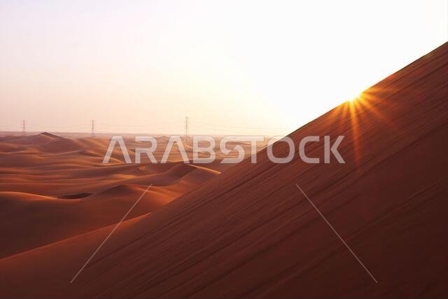 شروق شمس ساطع على الكثبان الرملية الحمراء لصحراء الدهناء في الرياض، المملكة العربية السعودية. بدايات جديدة، رمز للأمل ومستقبل أكثر إشراقاً. شروق شمس ساطع على الكثبان الرملية الحمراء لصحراء الدهناء في الرياض، المملكة العربية السعودية. بدايات جديدة، رمز للأمل ومستقبل أكثر إشراقاً.