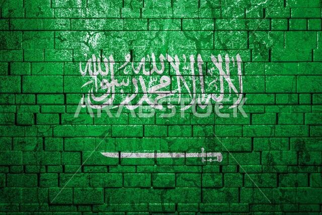 National flag of Saudi Arabia on brick  wall background.The concept of national pride and symbol of the country. Flag  banner on  stone texture backgr