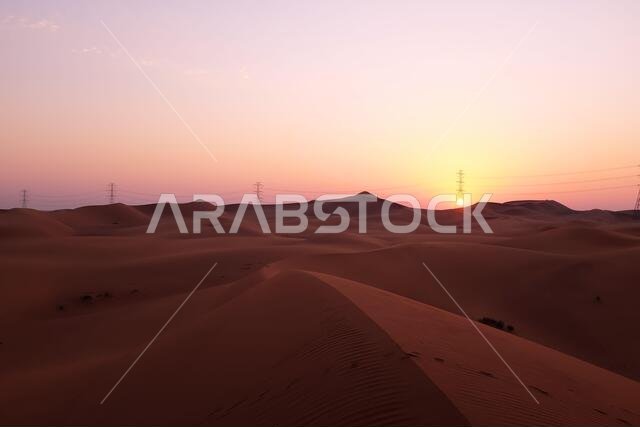 شروق الشمس بألوان الباستيل في صحراء الدهناء بالرياض، المملكة العربية السعودية. مفهوم البدايات الجديدة والأمل.