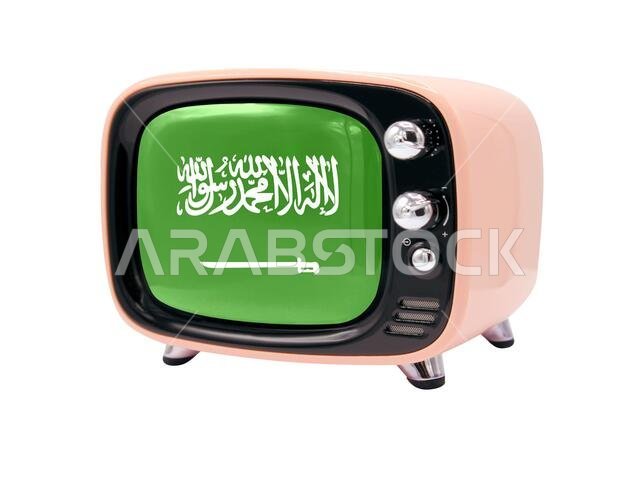 يظهر جهاز التلفزيون القديم ذو الطراز القديم معزولاً على خلفية بيضاء عليها علم المملكة العربية السعودية