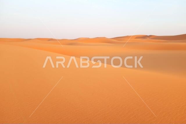 كثبان رملية برتقالية زاهية في صحراء الدهناء، الرياض، المملكة العربية السعودية.