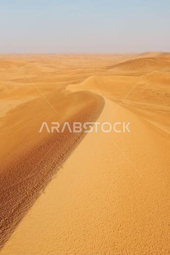 صورة بورتريه لكثبان رملية برتقالية زاهية في صحراء الدهناء، الرياض، المملكة العربية السعودية.