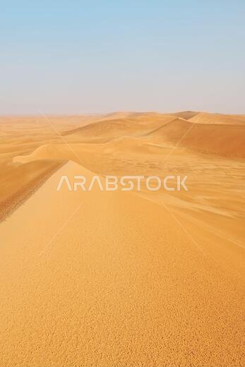 Portrait shot of bright orange desert landscape sand dunes in Al Dahna Desert, Riyadh, Saudi Arabia.
