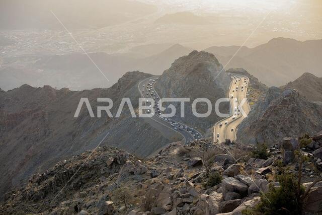 منظر غروب الشمس مع الجبال وطريق جبلي. الطائف، المملكة العربية السعودية