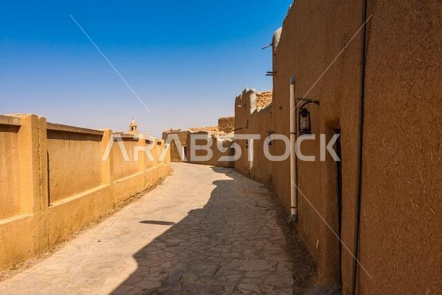 شارع ضيق في قرية المجمعة العربية التقليدية المبنية من الطوب اللبن، المملكة العربية السعودية