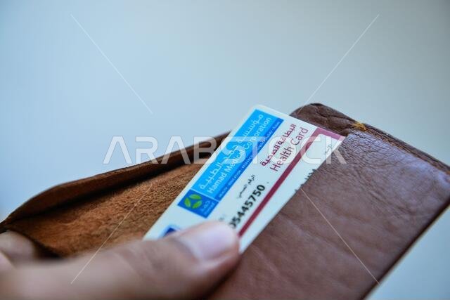 بطاقة الهوية القطرية والبطاقة الطبية باللون البني على خلفية بيضاء بطاقة الهوية القطرية والبطاقة الطبية باللون البني على خلفية بيضاء